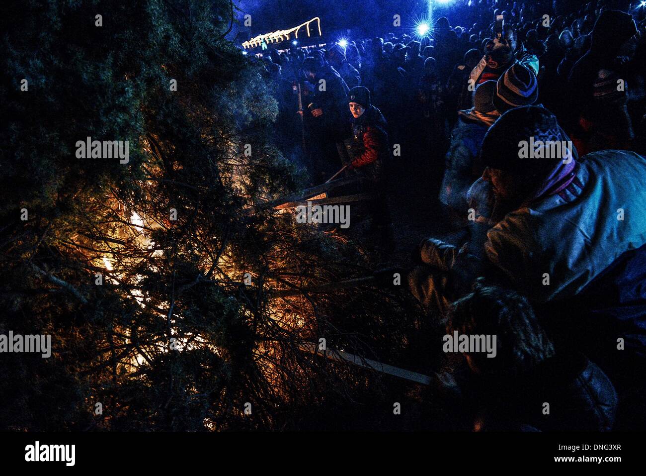 Thessalonique, Grèce. Le 24 décembre, 2013. Les enfants ont mis le feu à l'arbre pendant la veille de Noël. La veille de Noël de la ville de Florina en Grèce du Nord et les villages environnants une tradition particulière se fait appelé ãƒæ'Ã'àƒ¢â''àƒ ?š š ?l''firesÃƒAE'Ã'Â'''Àƒæ Sàƒæ ?š Â''. Au cours de cet événement les habitants des grands incendies dans chaque partie de la ville. Cette tradition est dit que éloigne les mauvais esprits et symbolise les bergers qui visitent le nouveau-né le Christ. L'éclat de l'incendie devrait réchauffer l'enfant. Autour du feu, les habitants et les touristes de la danse, de boire du vin et manger de la soupe de haricots.Photo : Giannis Papan Banque D'Images