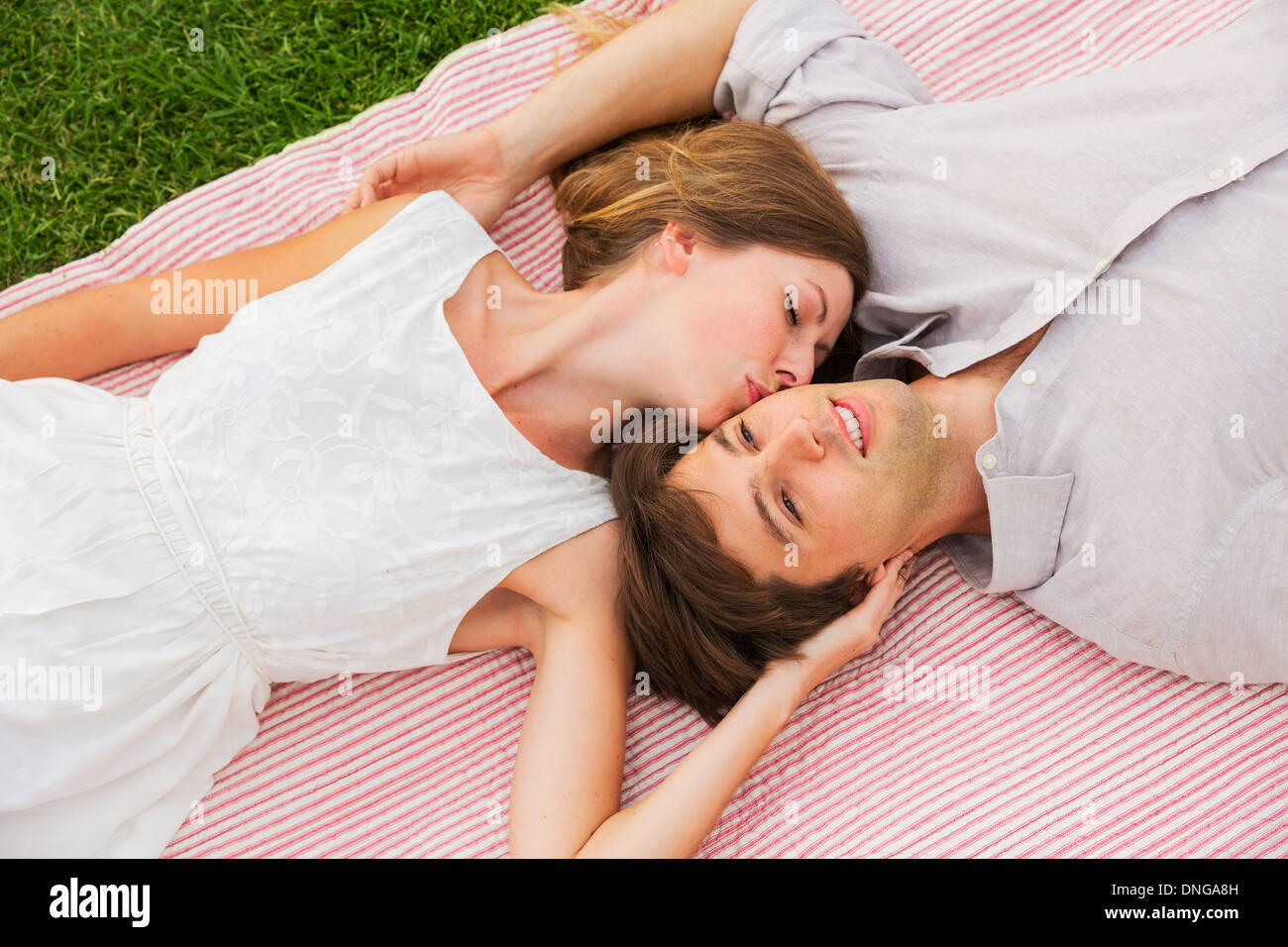 Pique-nique dans le parc romantique, loving couple cuddling on blanket outdoors on grass Banque D'Images