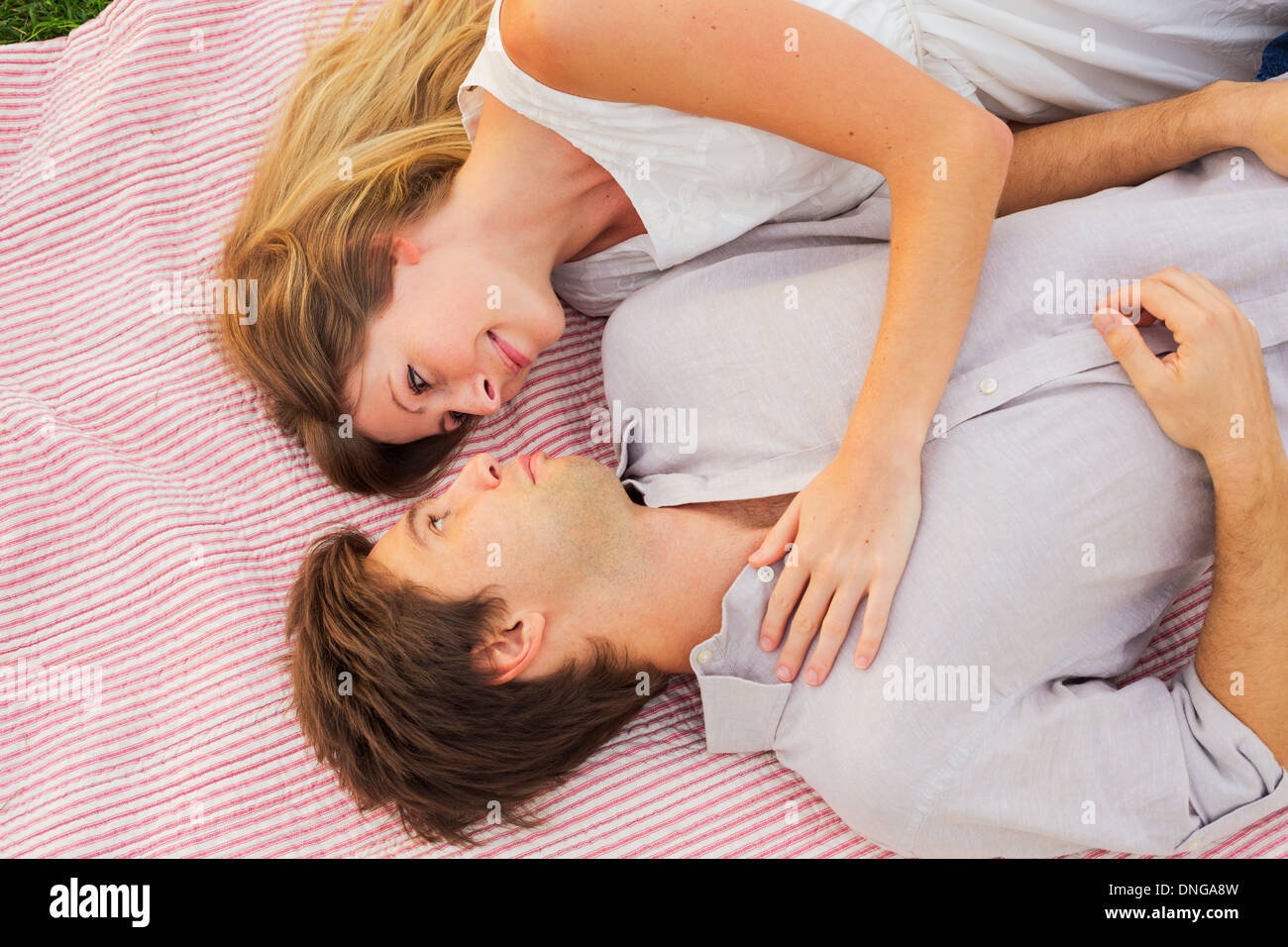 Pique-nique dans le parc romantique, loving couple cuddling on blanket outdoors on grass Banque D'Images