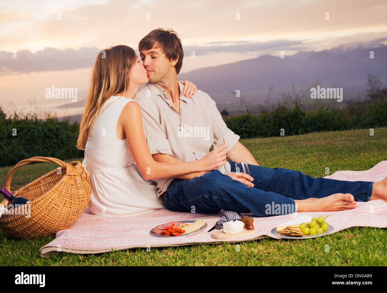 Beau couple romantique au coucher du soleil sur la campagne en pique-nique Banque D'Images