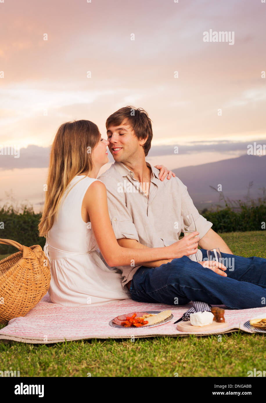 Beau couple romantique au coucher du soleil sur la campagne en pique-nique Banque D'Images