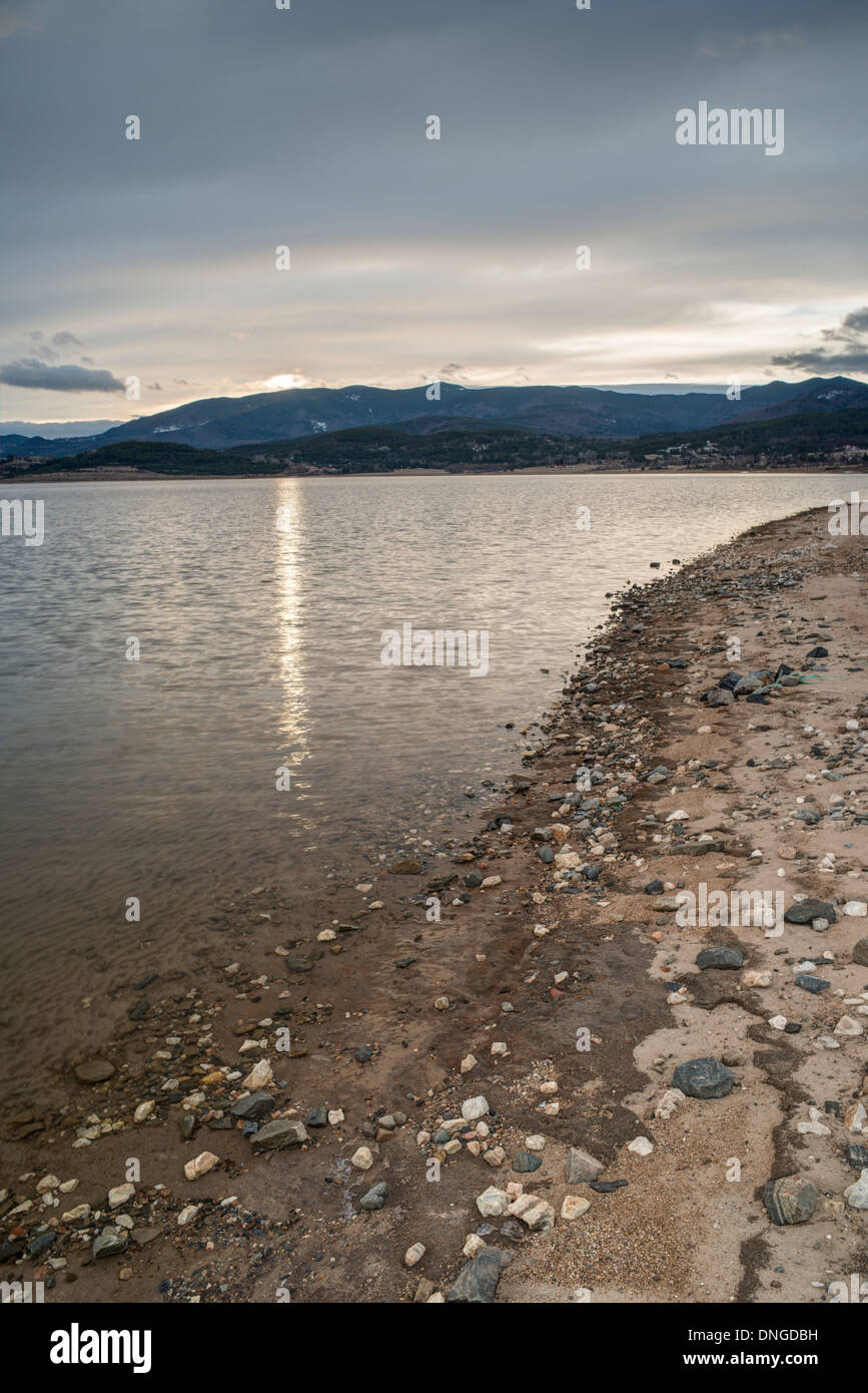 Barrage en montagne sur le lever du soleil. Ciel nuageux Banque D'Images