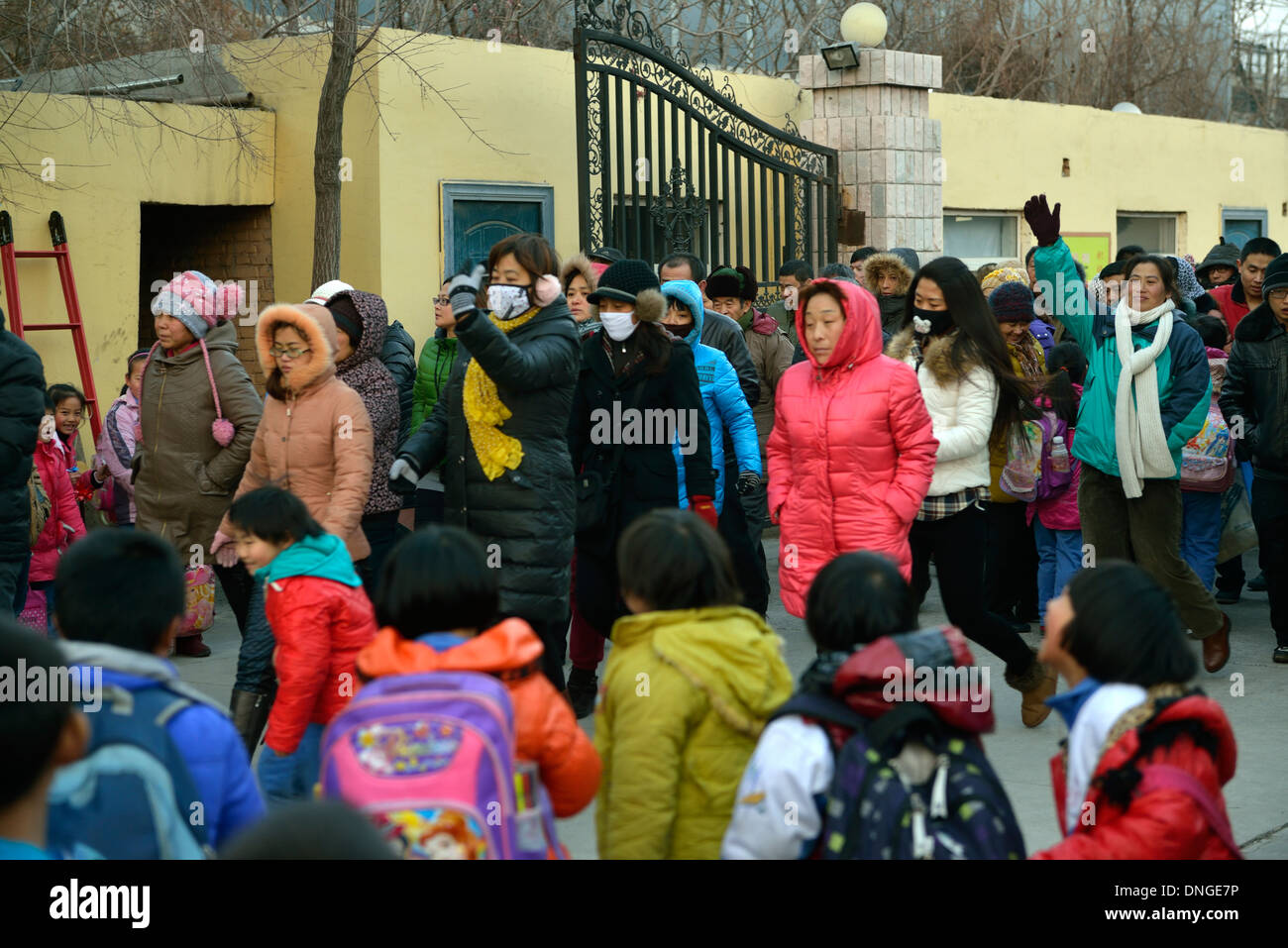 Les parents viennent chercher leurs enfants dans une école de migrants lorsqu'il n'y a plus de cours à Beijing. 25-Déc-2013 Banque D'Images