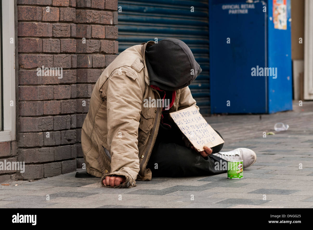 Sans-abri mendier dans Sauchihall Street à Glasgow, Écosse, Royaume-Uni. Il est assis à côté d'un magasin qui a été fermé. Banque D'Images