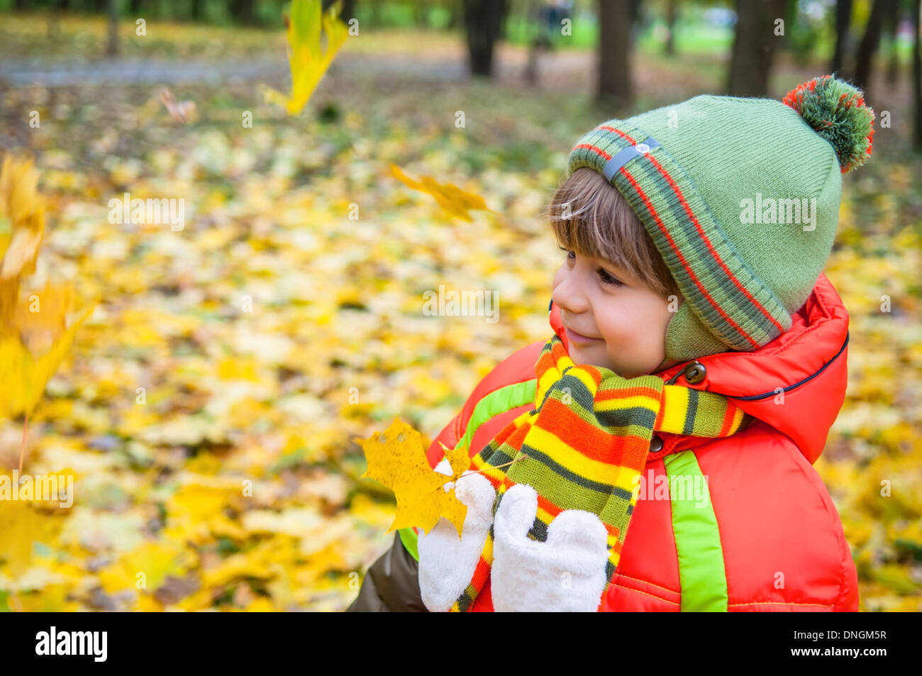 Heureux l'enfant smiling in autumn park Banque D'Images
