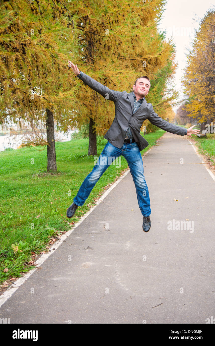 Young handsome man jumping in autumn park Banque D'Images