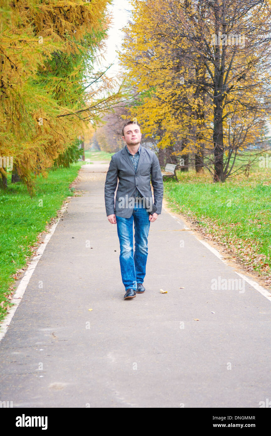 Young handsome man walking in autumn park Banque D'Images