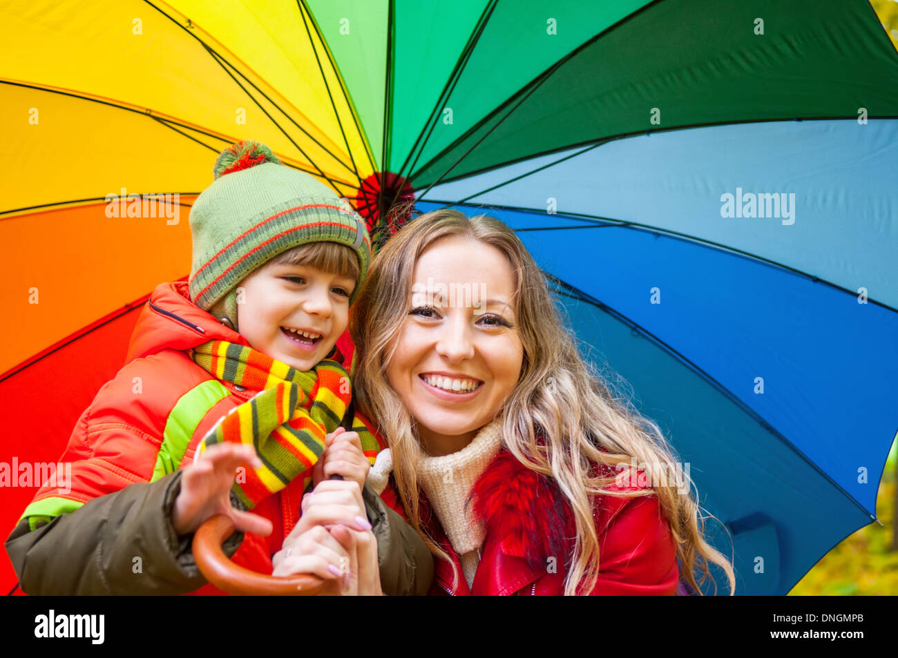 Famille heureuse avec un parapluie multicolore en automne park Banque D'Images