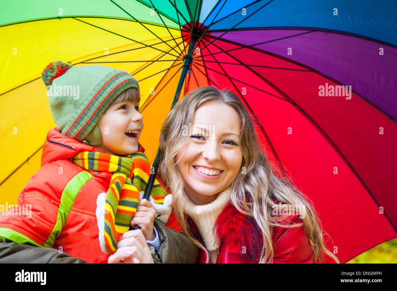 Famille heureuse avec un parapluie multicolore en automne park Banque D'Images
