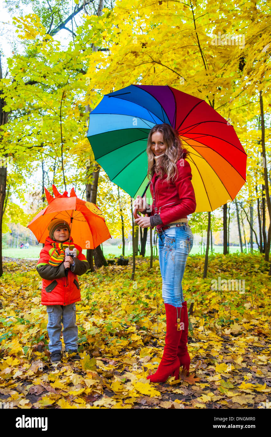 Une famille heureuse avec des parasols multicolores en automne park Banque D'Images