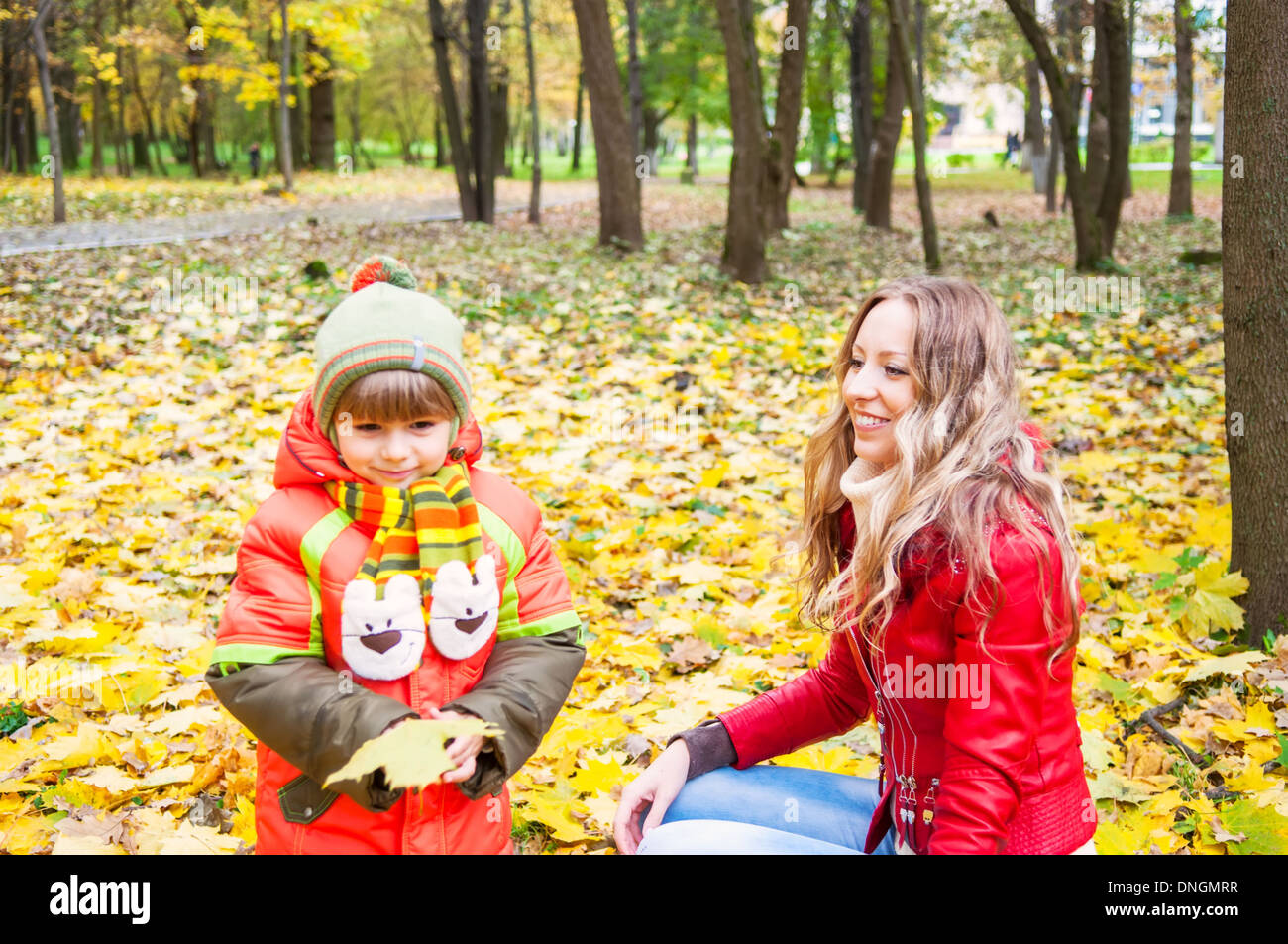 Happy Family smiling and holding Autumn Leaves, focus om mère Banque D'Images