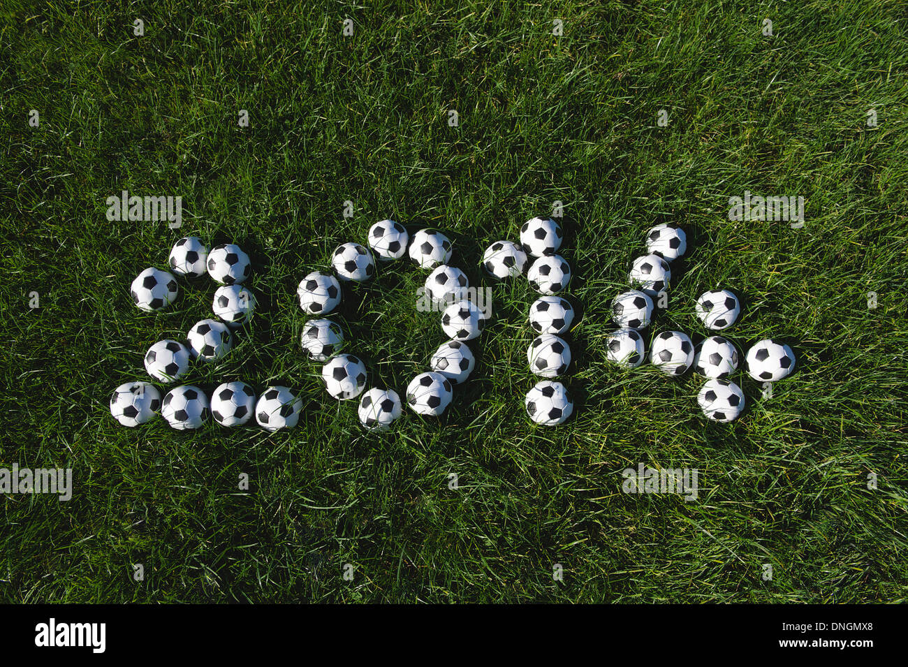 Message pour 2014 faite avec de petits ballons de soccer football on Green grass Banque D'Images