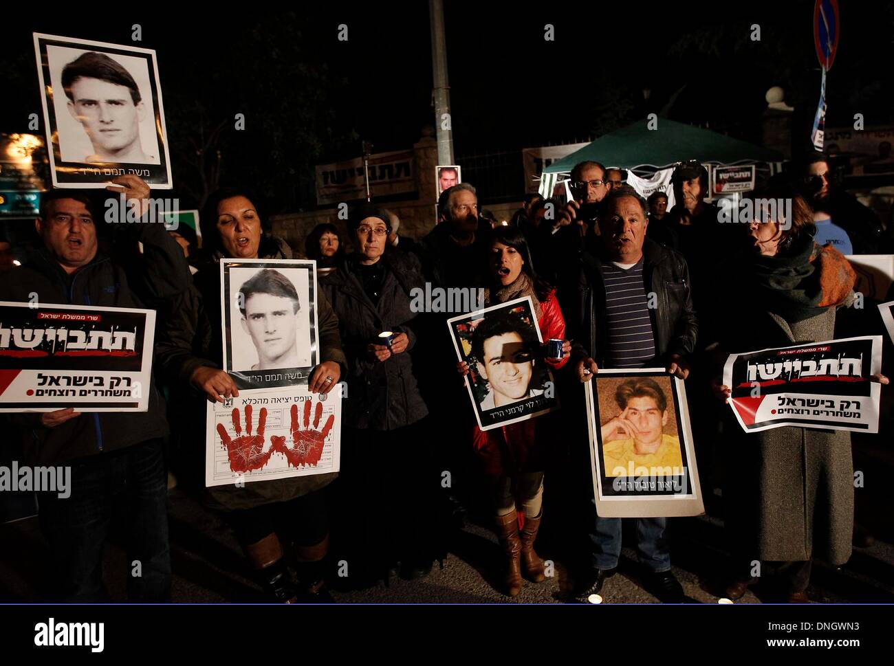 Jérusalem, Israël. Dec 29, 2013. Des parents d'Israéliens qui ont été tués par des militants palestiniens détiennent des bougies et des panneaux indiquant 'Stop à la libération d'assassins' et 'honte ! Seul Israël presse assassins' en hébreu au cours d'une manifestation en face de la résidence du Premier ministre israélien à Jérusalem, le 28 décembre 2013. Le gouvernement israélien a approuvé dimanche la libération de plus de 26 détenus palestiniens dans le cadre de gestes de bonne volonté pour la reprise de ses négociations de paix avec les Palestiniens. Source : Xinhua/Alamy Live News Banque D'Images