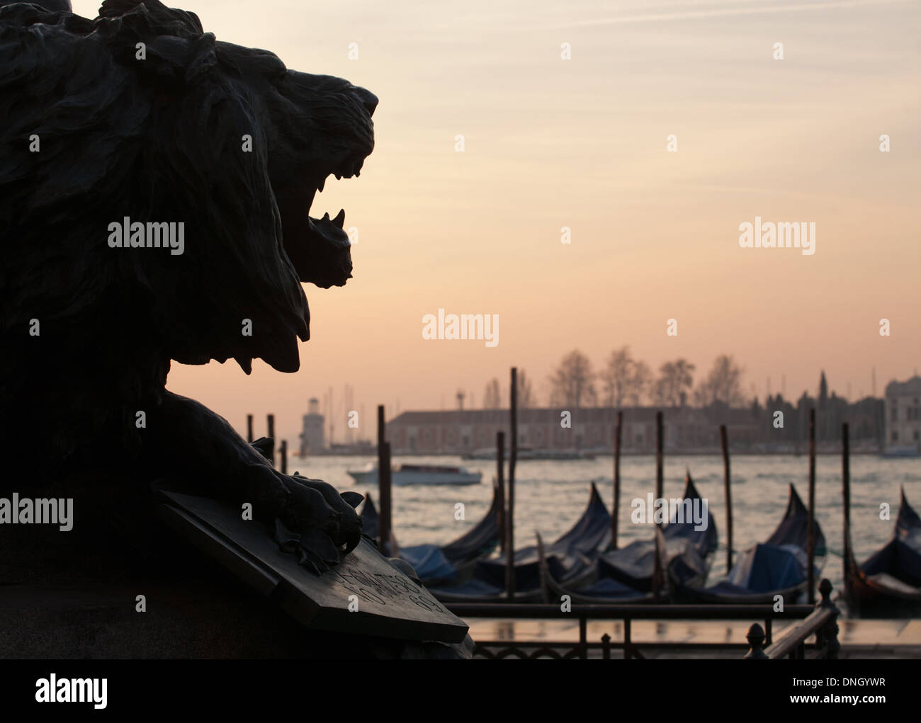 Silhouette noire du lion statue tête sur la lagune de Venise et les gondoles fond coucher de soleil Banque D'Images