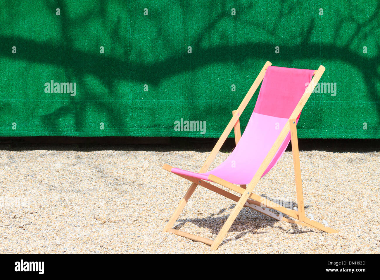 Chaise pliante en face de mur vert Banque D'Images