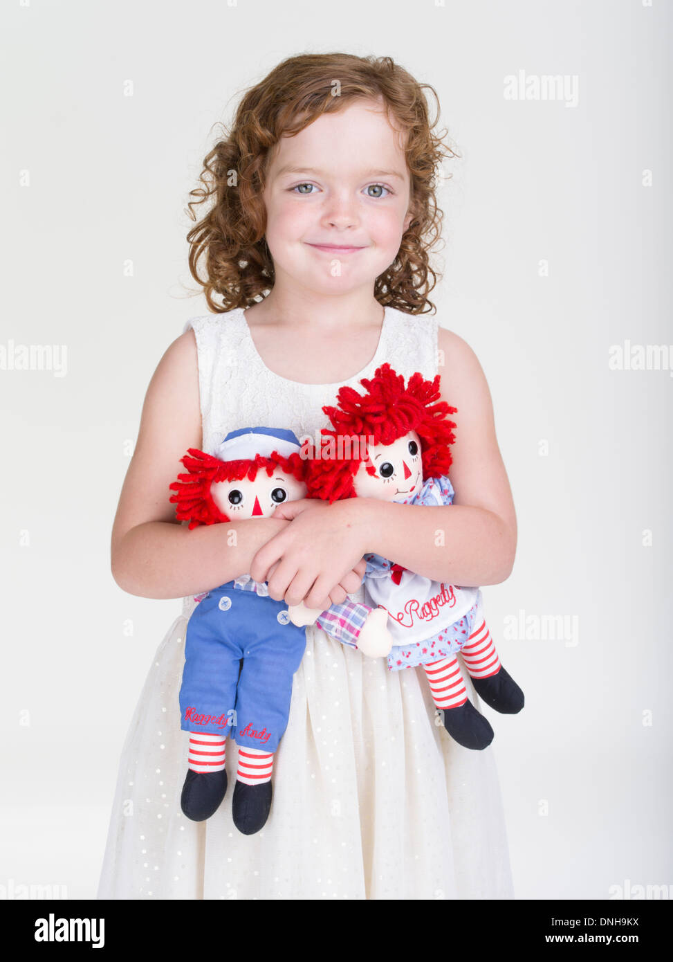 Raggedy Ann et Andy des jouets d'enfants organisé par jeune fille aux cheveux rouges. Banque D'Images