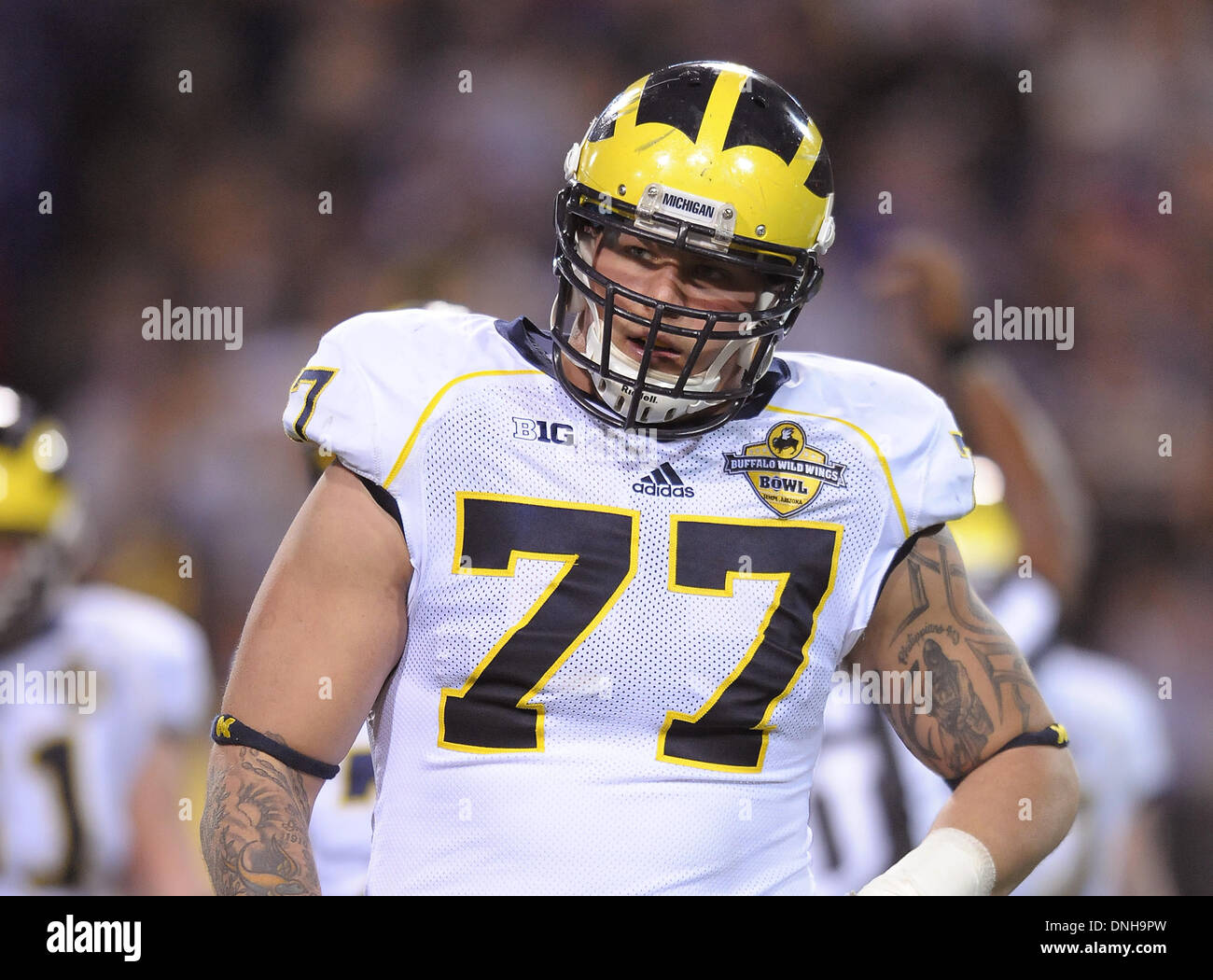 Tempe, AZ, États-Unis d'Amérique. 28 Dec, 2013. 28 décembre 2013 à Tempe, AZ.offensive tackle (Michigan) 77 Lewan Taylor en action, contre une défense très agressive des chats sauvages, selon les experts de football Lewan devrait être un top 10 pick dans la NFL. Les Wolverines du Michigan et Kansas State Les Chats Sauvages s'affrontent pour la première fois dans l'histoire programsÃâ ¢ le Samedi, Décembre 28, 2013 dans le Buffalo Wild Wings Bol à Tempe, Arizona. Les Chats Sauvages accablé les Wolverines et les ont battus 31-14. (Crédit obligatoire : Jose Marin / MarinMedia.org / Cal Sport Media) (p complète © csm/Alamy Live News Banque D'Images