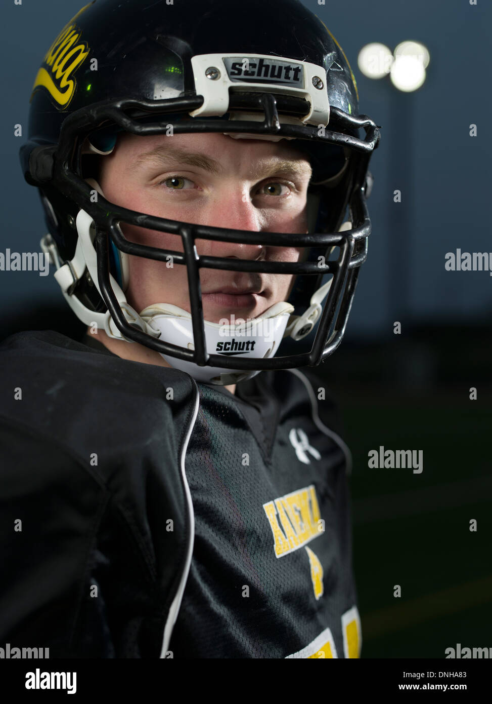 American High School Football Player en uniforme avec casque et le football. Banque D'Images