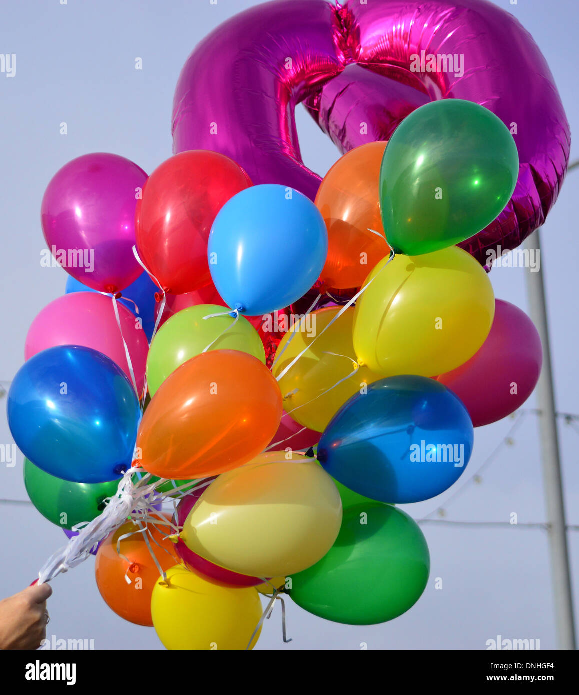 Grand groupe de ballons colorés contre un ciel bleu Banque D'Images