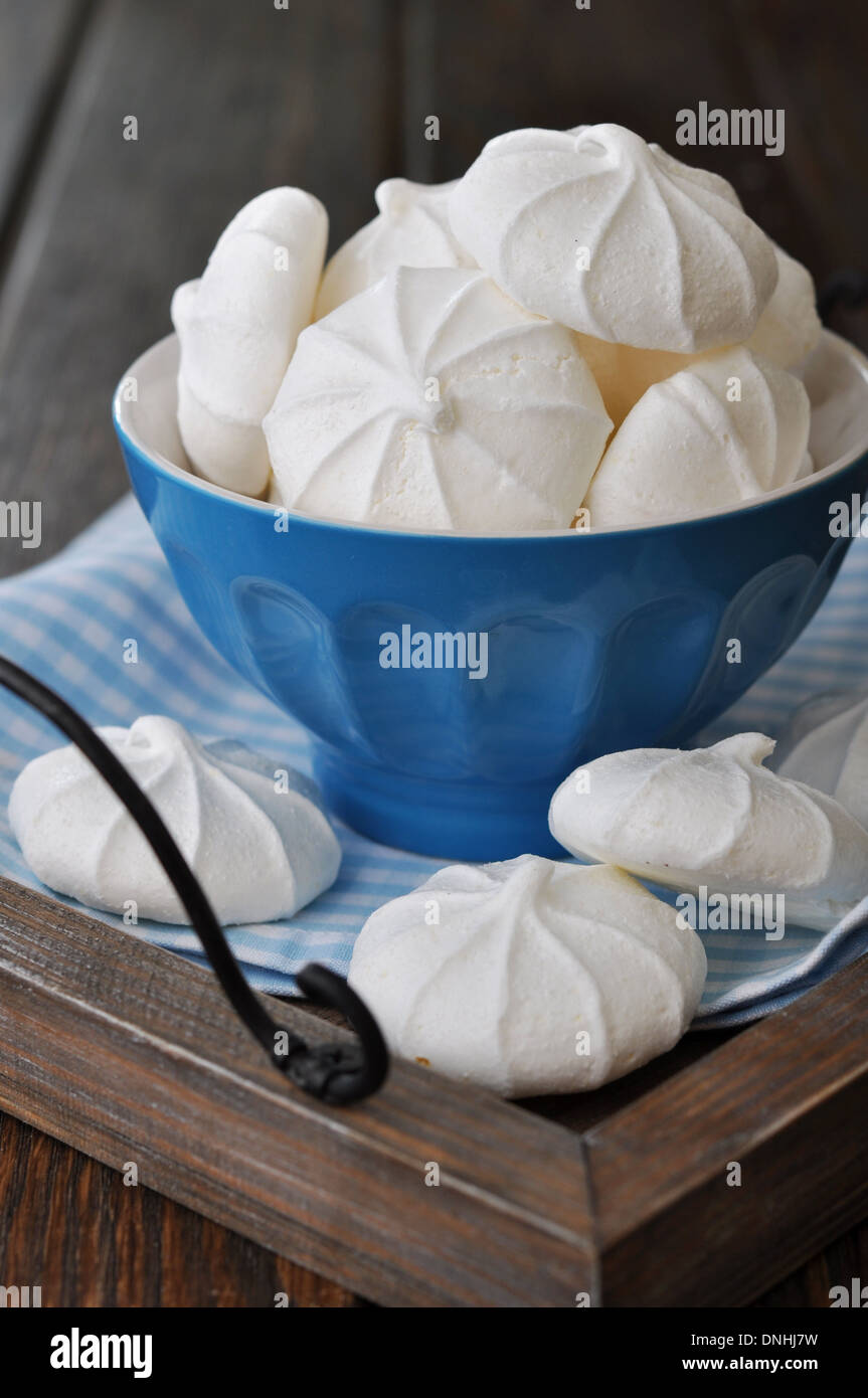 La meringue cookies dans bol bleu sur plateau en bois Banque D'Images