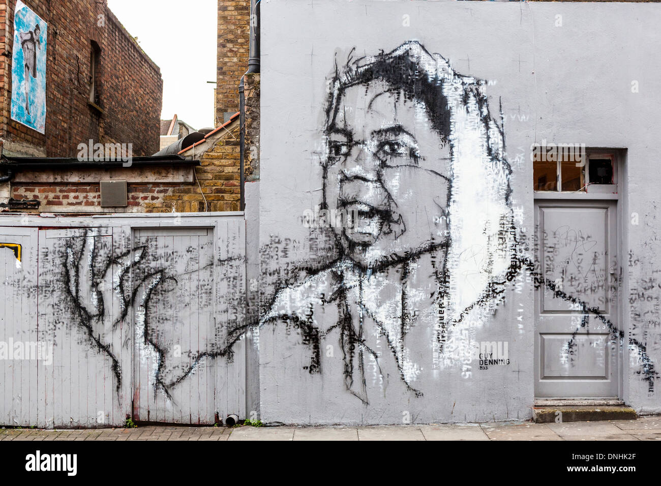 Street Art Par Guy Denning - grand portrait de l'homme dans l'écharpe blanche sur mur dans le Hanbury Street, à côté de Brick Lane, East London, UK Banque D'Images