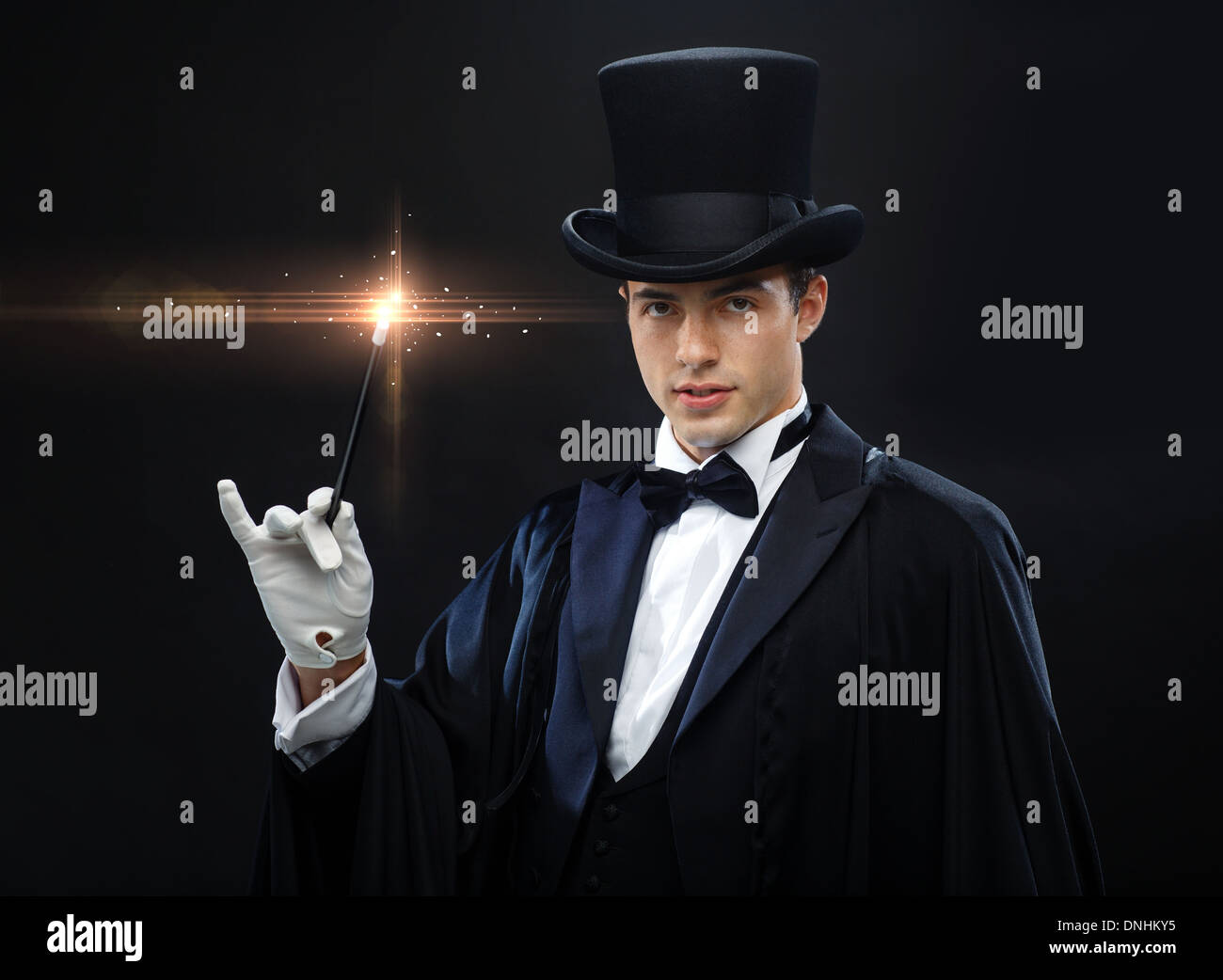 Magicien dans top hat avec Magic wand montrant trick Banque D'Images