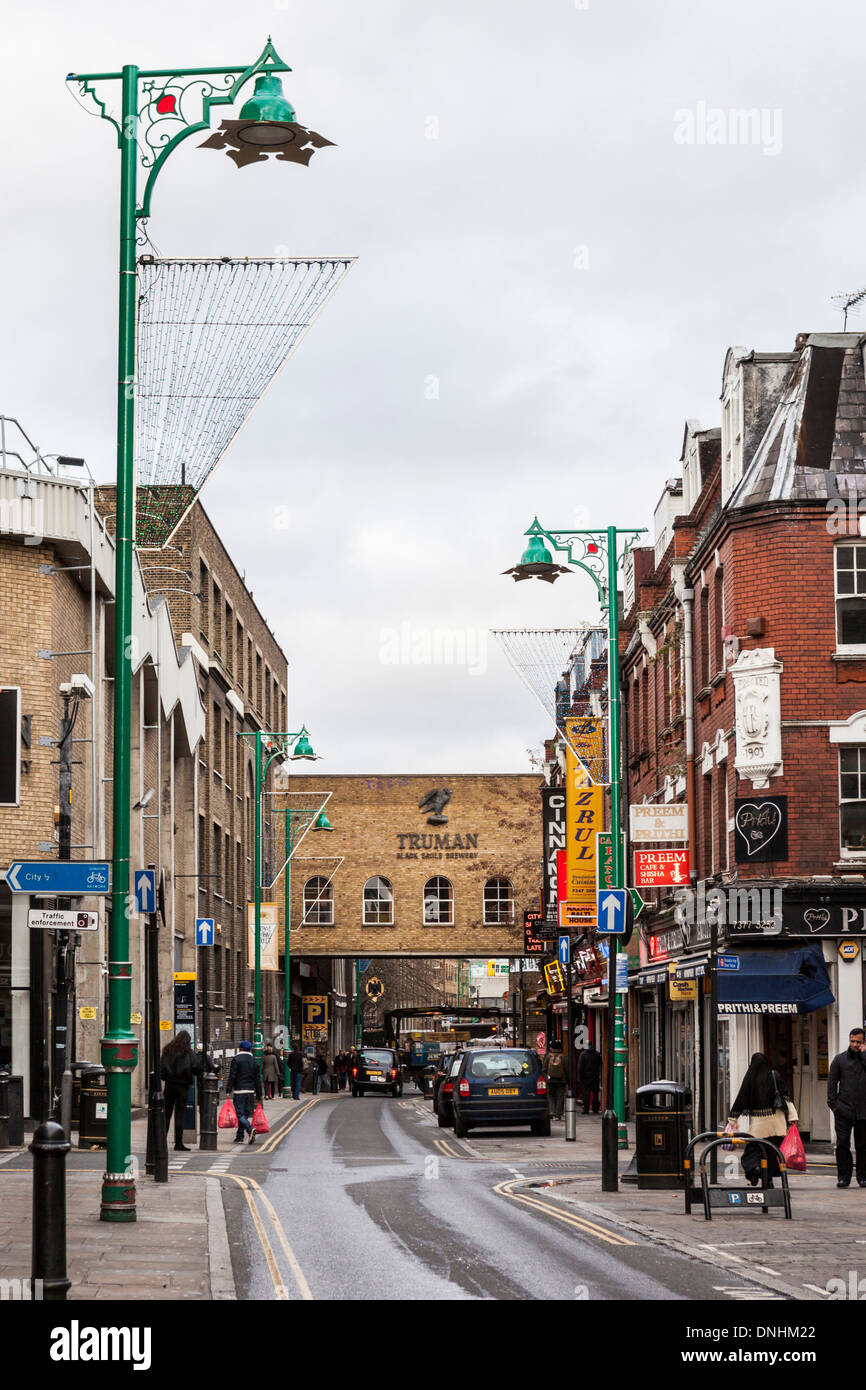 Lampadaires avec des lumières de Noël, le cari maisons et Truman Brewery Black Eagle bridge à Brick Lane, East London, UK Banque D'Images