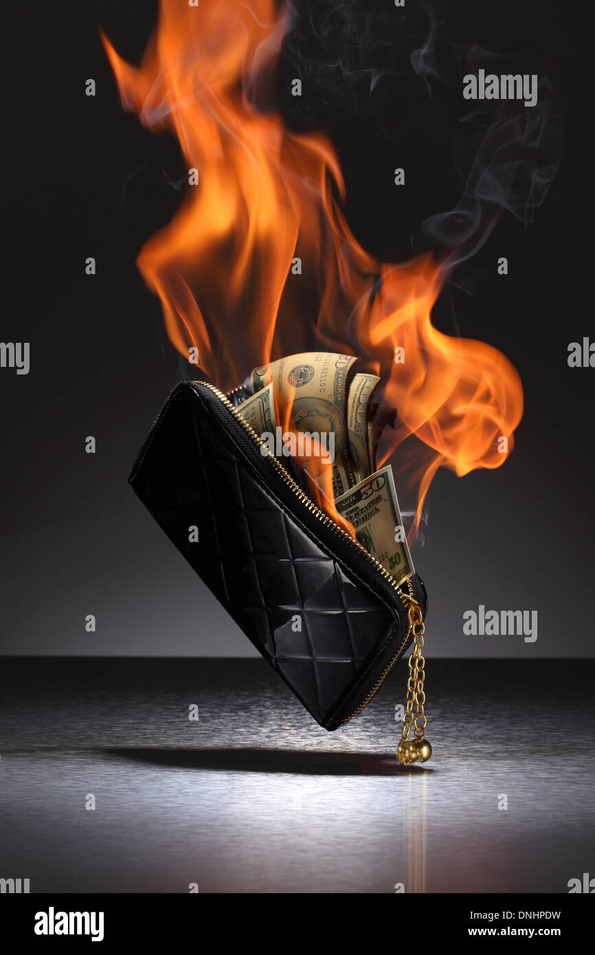 Un portefeuille en cuir brun rempli de cartes de crédit et de l'argent sur le feu. Banque D'Images