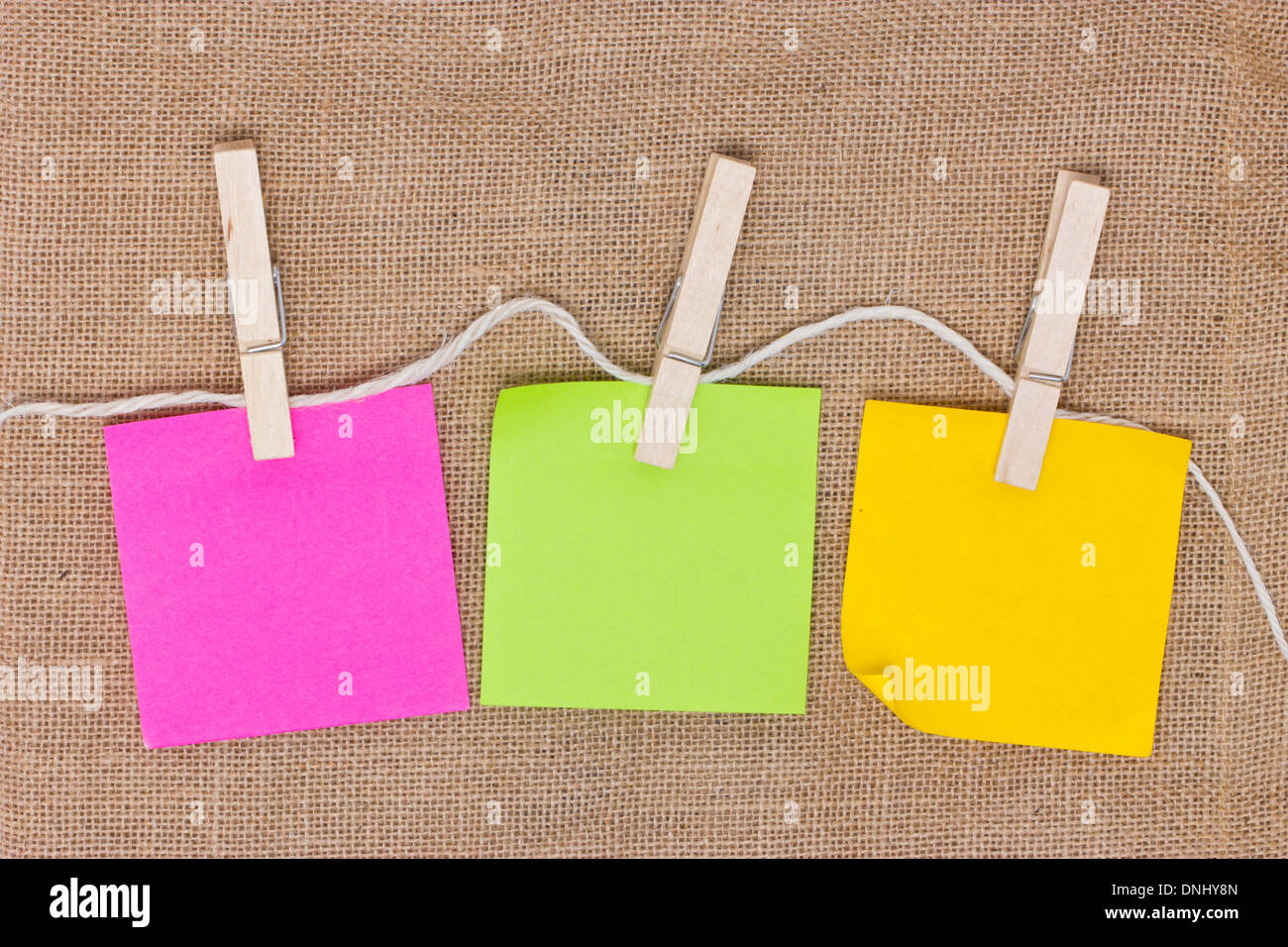 Notes autocollantes colorées avec de jute linge sur arrière-plan. Banque D'Images