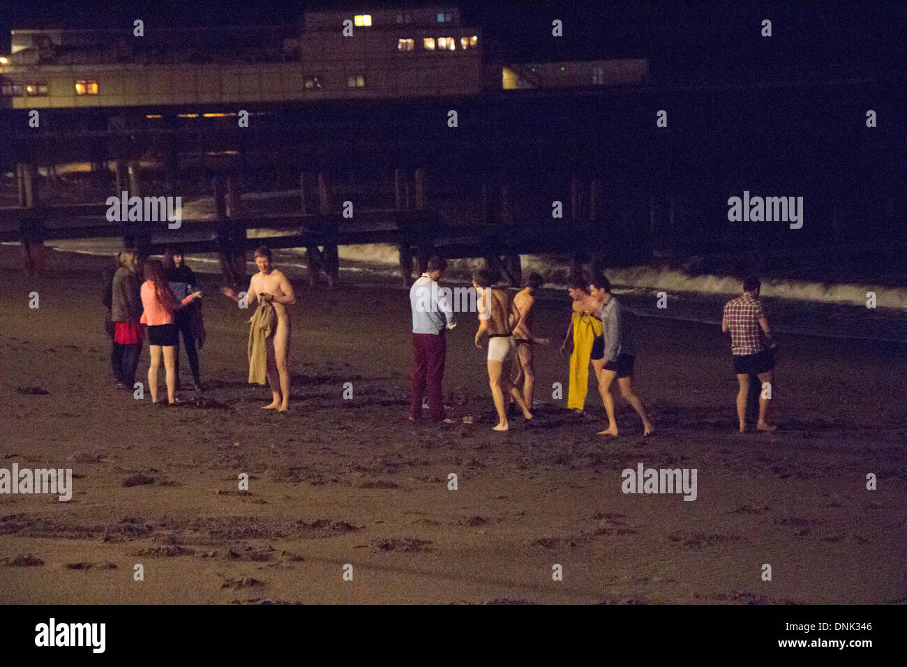 Aberystwyth, Pays de Galles, Royaume-Uni. 1er janvier 2014. Late Night Revelers décoller pour une baignade pour célébrer la nouvelle année à Aberystwyth. Crédit : Jon Freeman/Alamy Live News Banque D'Images