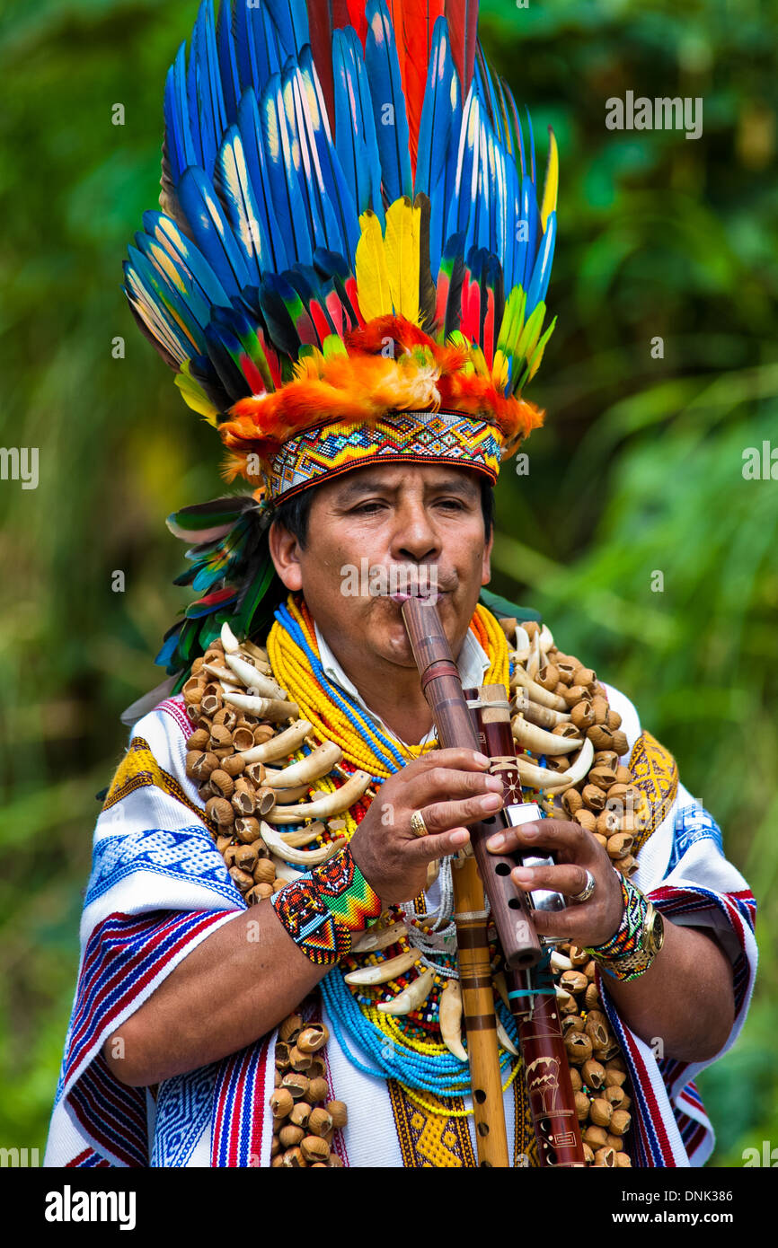 Un chaman de la tribu des kamentsá, portant un couvre-chef en plumes colorées, joue de la flûte pendant le carnaval en sibundoy, Colombie. Banque D'Images