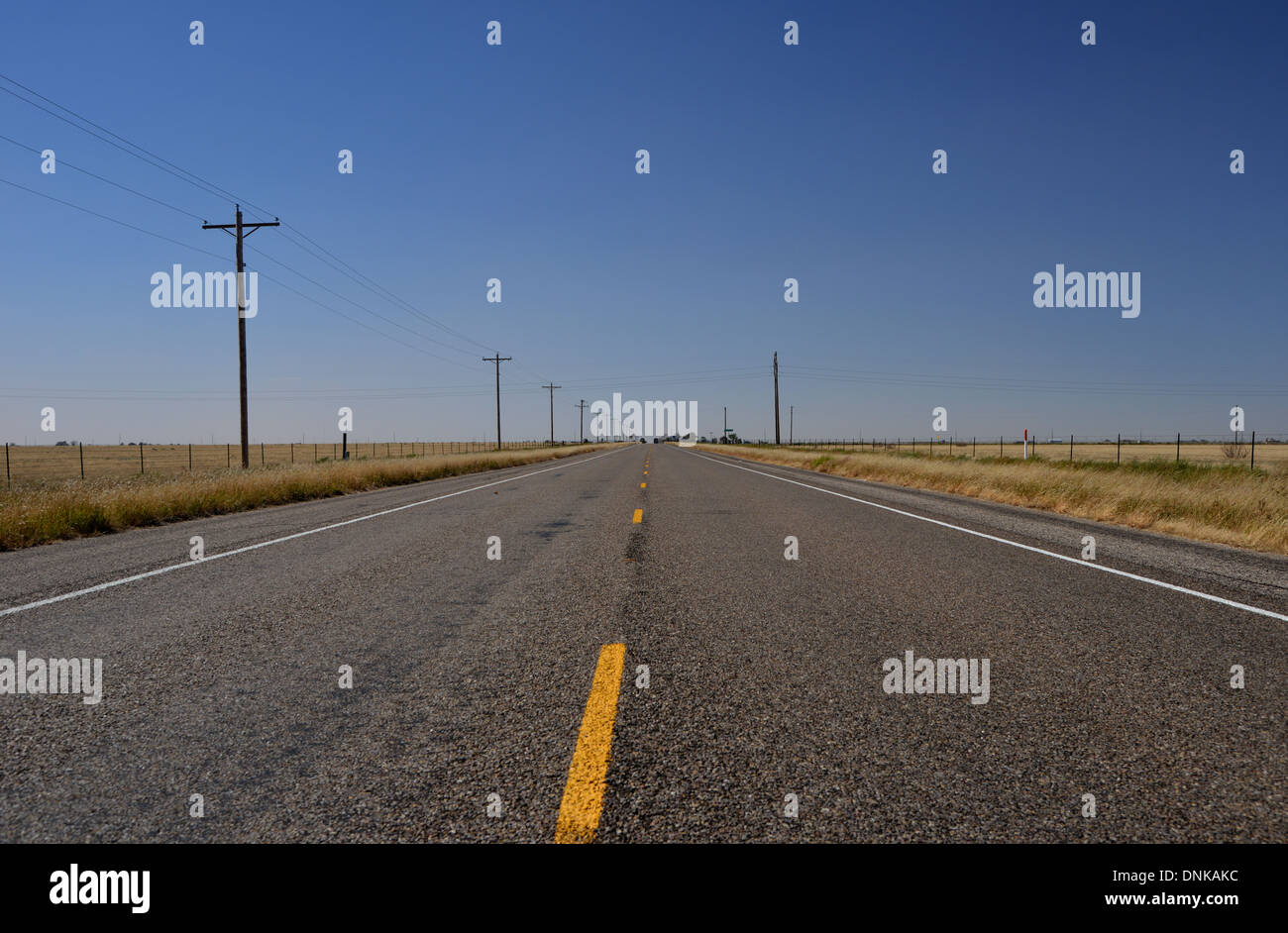 La route 66, Texas, USA. Longue route droite disparaît dans la distance sous un ciel bleu solitaire Banque D'Images