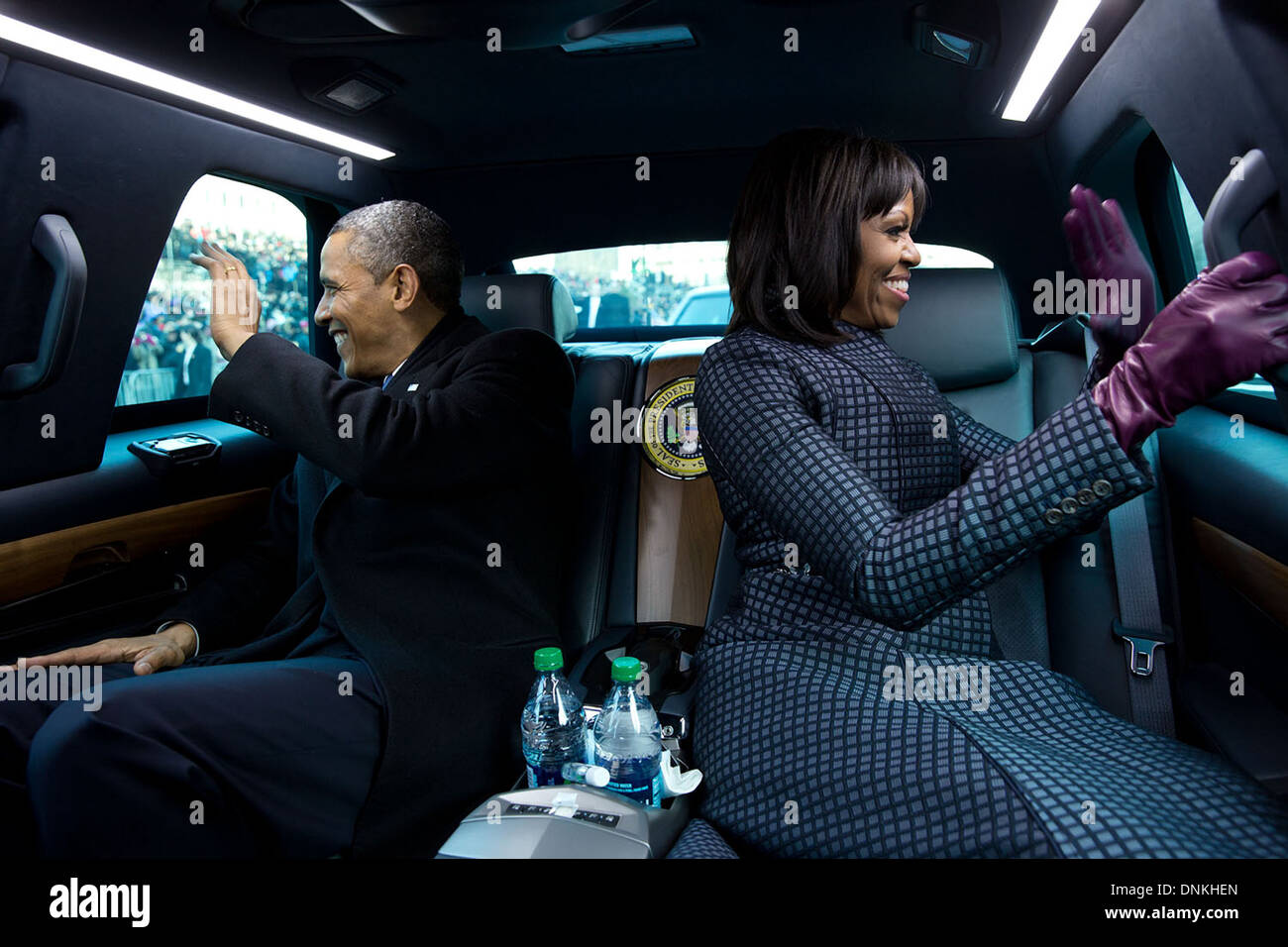 Le président américain Barack Obama et la Première Dame Michelle Obama vague aux partisans de l'intérieur de la limousine présidentielle comme ils montent dans le premier défilé le 21 janvier 2013 à Washington, DC. Banque D'Images