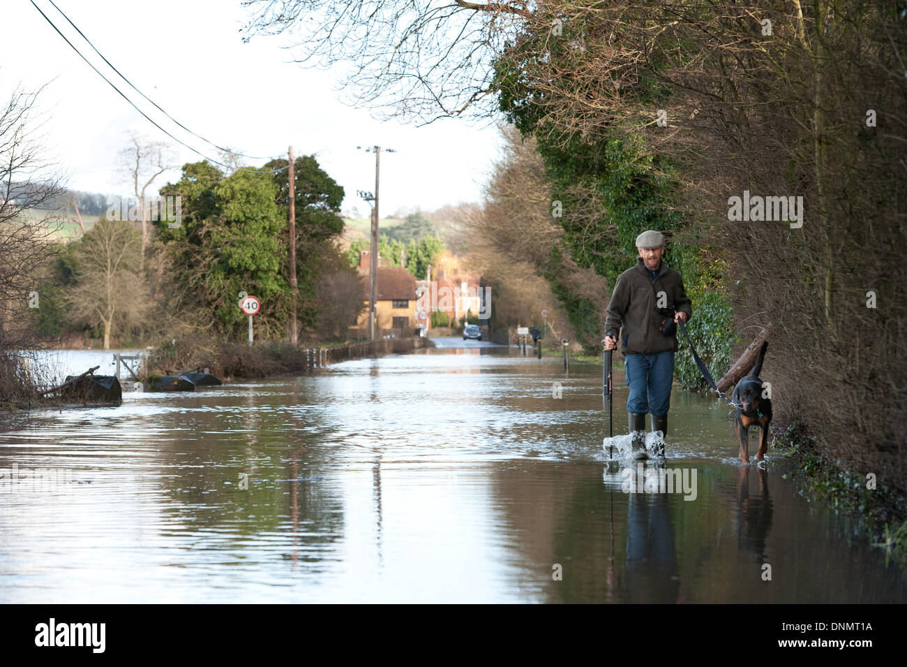 Yalding, Kent, UK. 2 janvier 2014. L'Agence de l'environnement a émis un avertissement d'inondation pour Yalding Village du comté de Kent Le premier pour 2014 le jeudi 2 janvier. Lee Road l'entrée du village avec propriétaire de chien bravant le chemin et inondé road Crédit : Yon Marsh/Alamy Live News Banque D'Images