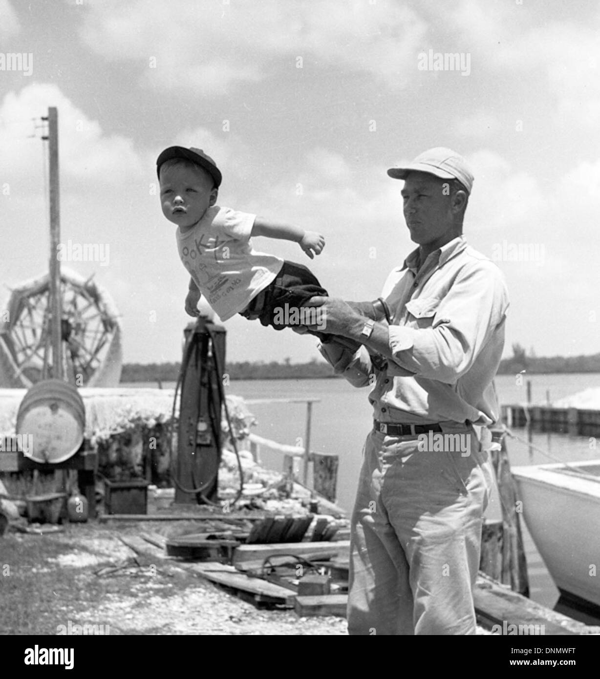 Cette image montre un pêcheur commercial et son fils sur les quais de Naples, en Floride, dans les années 1940 La photo fait partie de la collection Joseph Janney Steinmetz et met en lumière l'industrie de la pêche de la région. Banque D'Images