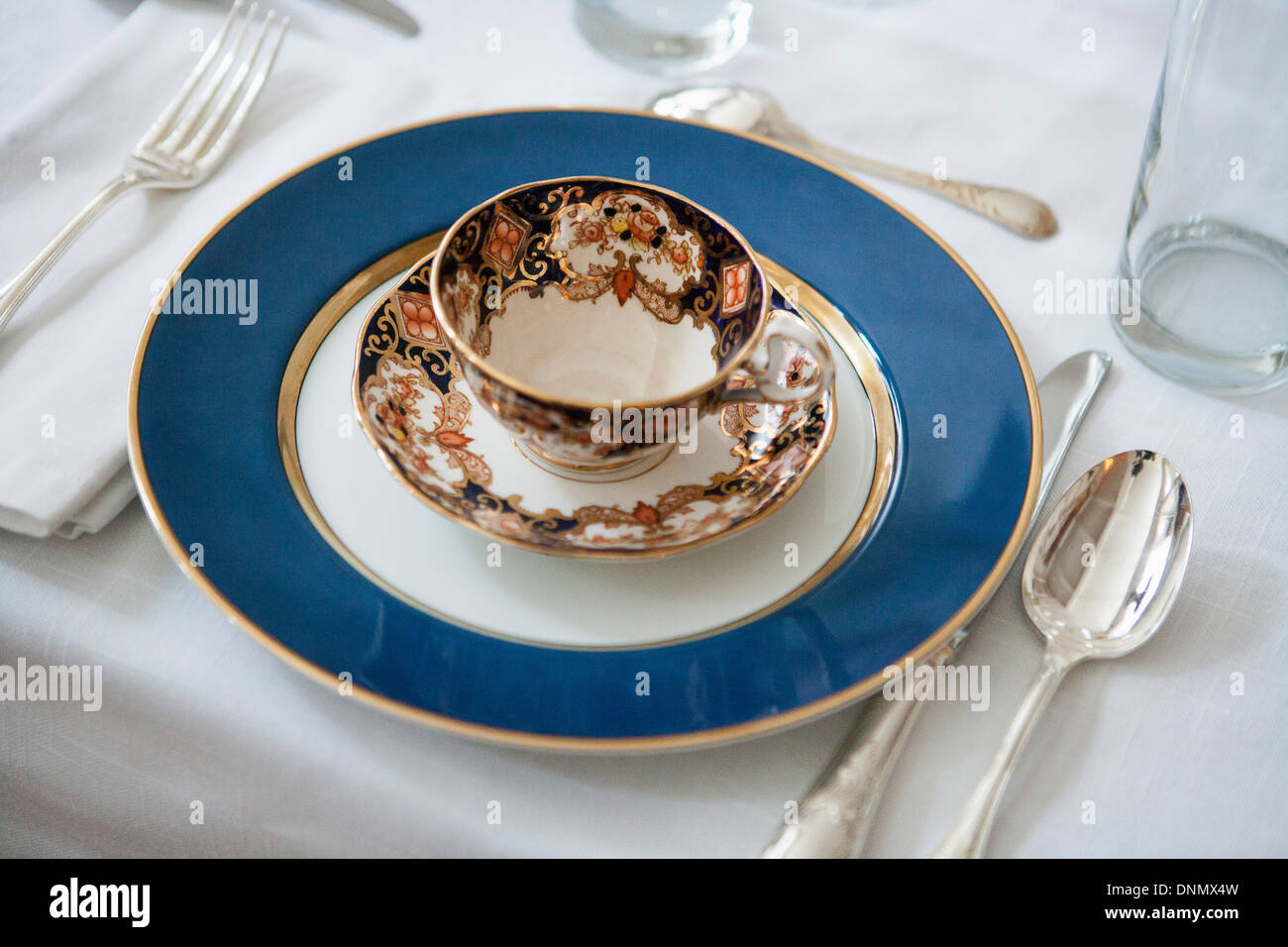 Table de salle à manger formelle avec Blue-Accented Tasse et soucoupe sur la plaque avec de l'Argenterie Banque D'Images