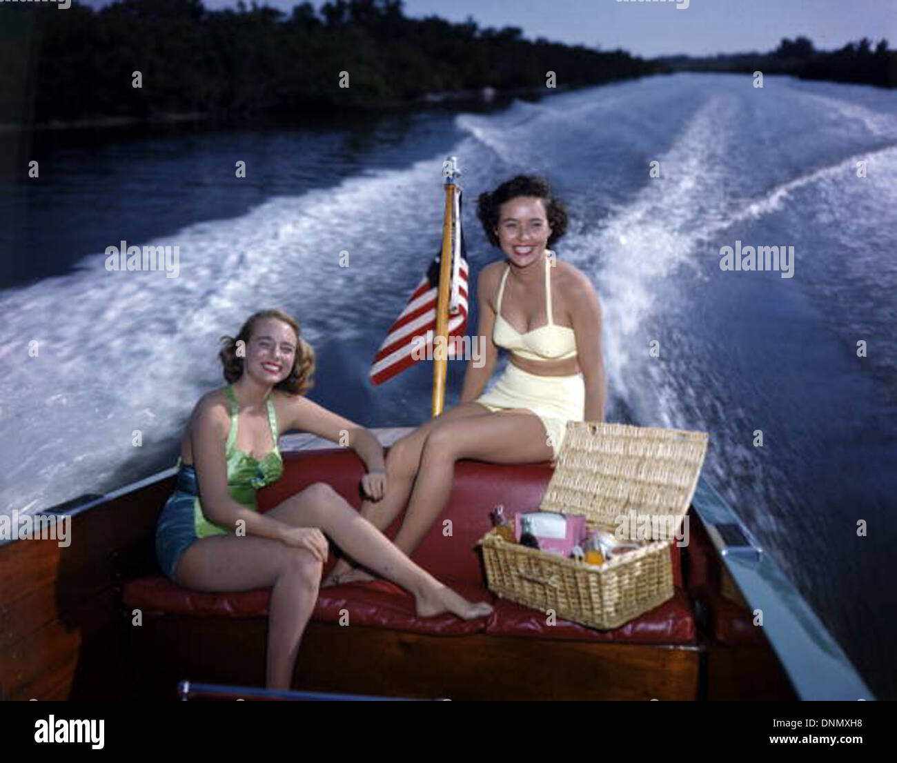 Lois Duncan Steinmetz et Polly gaines dans un bateau à moteur sur la baie de Sarasota, en Floride, dans les années 1950 Cette photographie, qui fait partie de la collection Joseph Janney Steinmetz, représente deux femmes faisant une promenade en bateau, reflétant la culture des loisirs du milieu du siècle. Banque D'Images