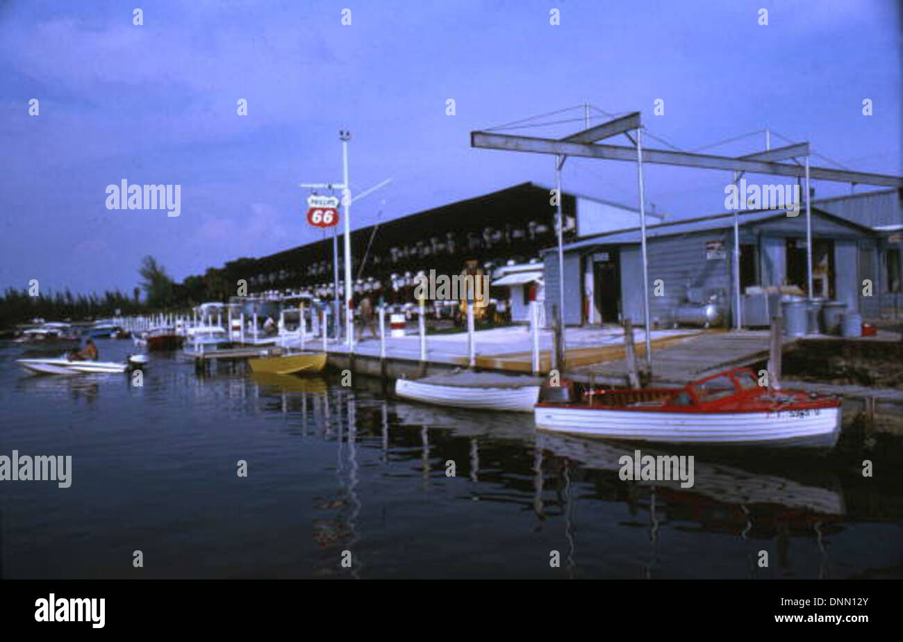 La marina de Denny Mercer à Sarasota, en Floride, photographiée dans les années 1960 L'image, qui fait partie de la collection Joseph Janney Steinmetz, montre des bateaux et des quais dans le comté de Sarasota avec la marque Phillips 66, mettant en valeur la culture nautique de la région. Banque D'Images