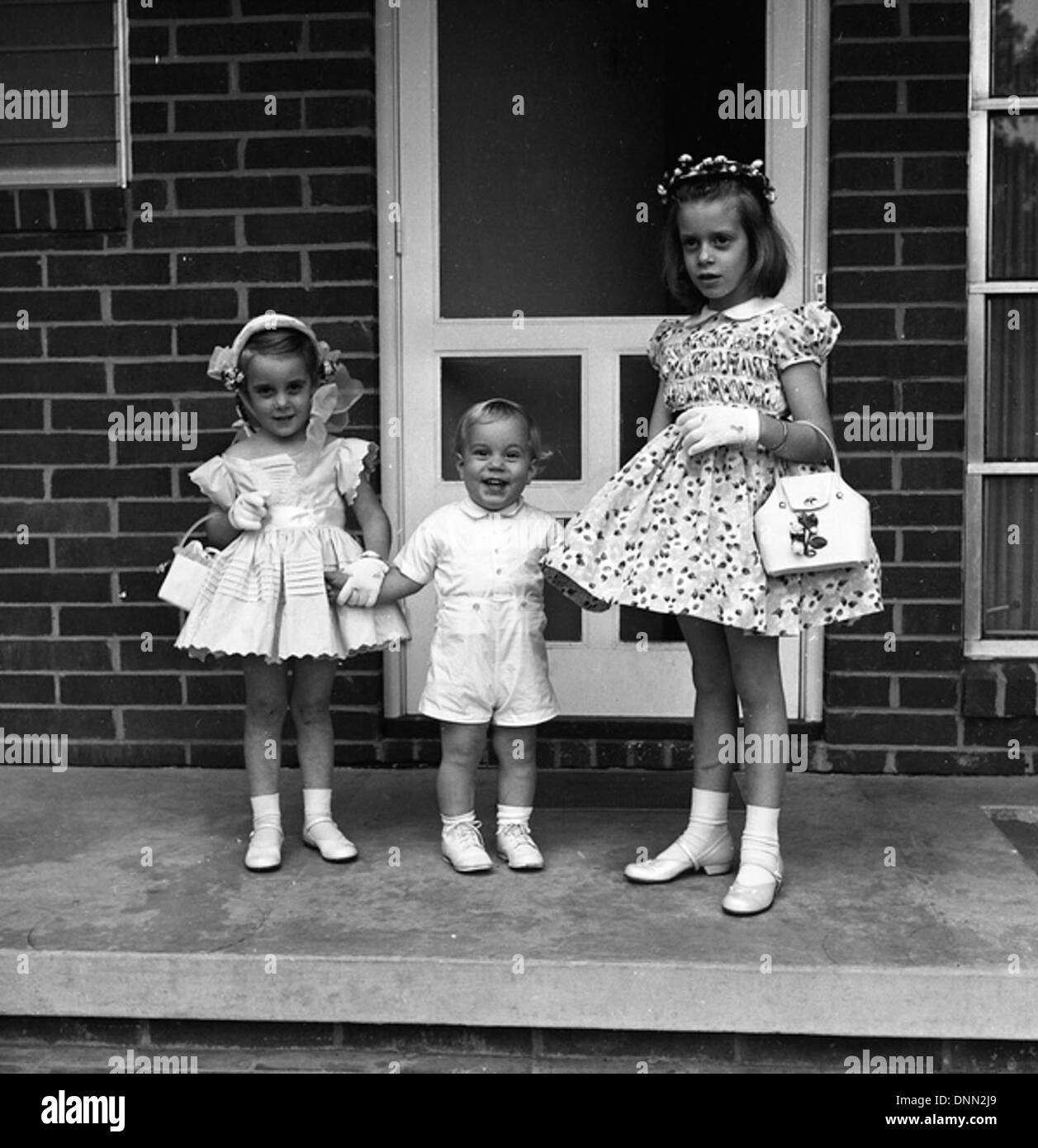 Cette image capture des enfants non identifiés habillés en tenue de Pâques à Tallahassee, en Floride, au cours des années 1950 La photo reflète une célébration typique de la fête avec des enfants portant des robes et des costumes, symbolisant les coutumes traditionnelles de Pâques. Banque D'Images