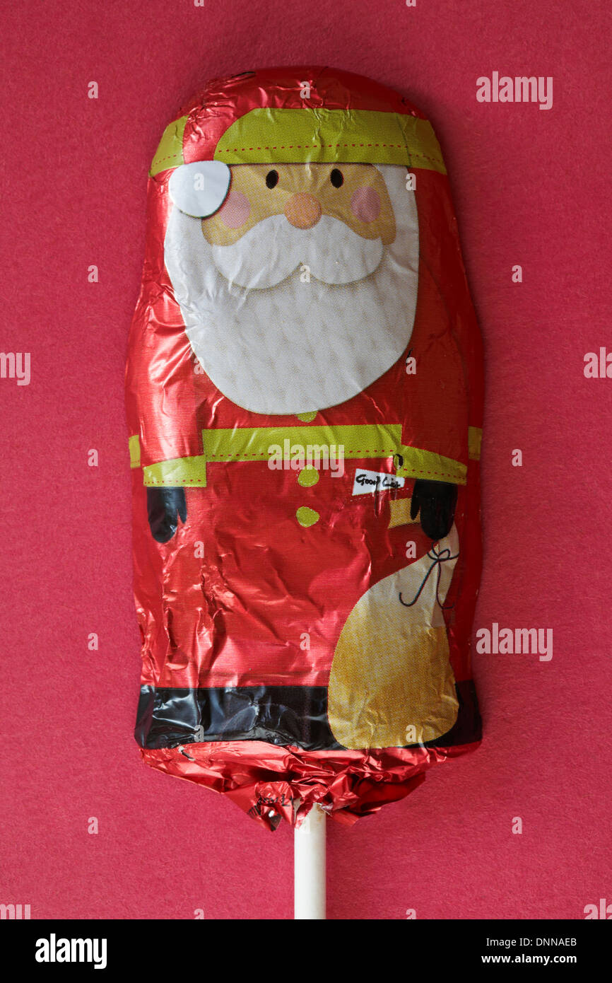 Chocolat au lait solide santa, Noël Fatther, chocolat lolly prêt pour Noël sur fond rouge Banque D'Images