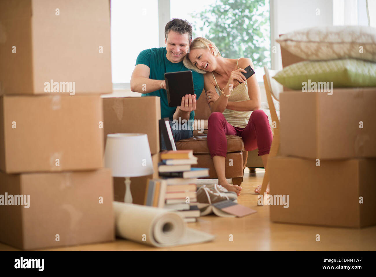 Couple using tablet pc in new home Banque D'Images