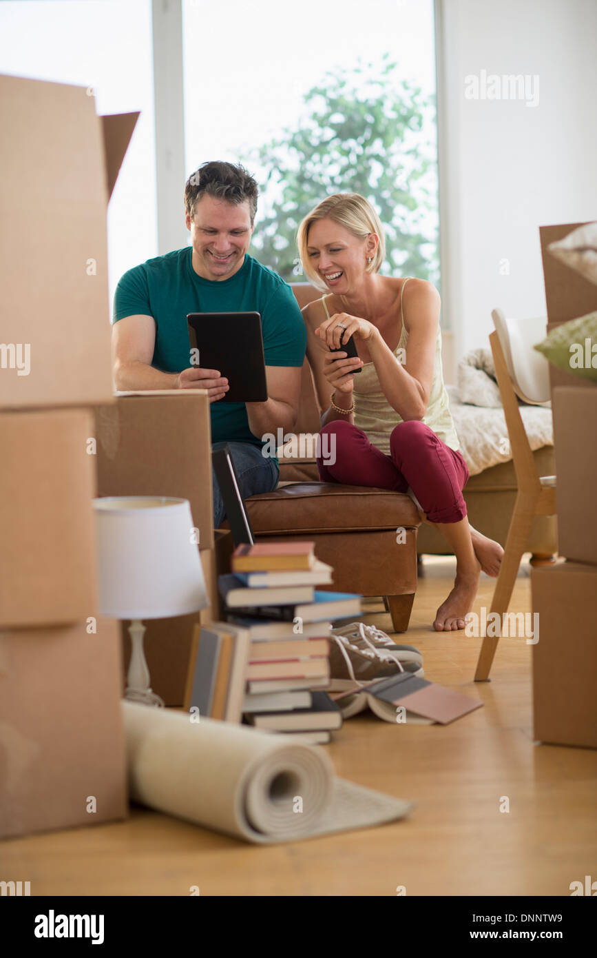 Couple using tablet pc in new home Banque D'Images
