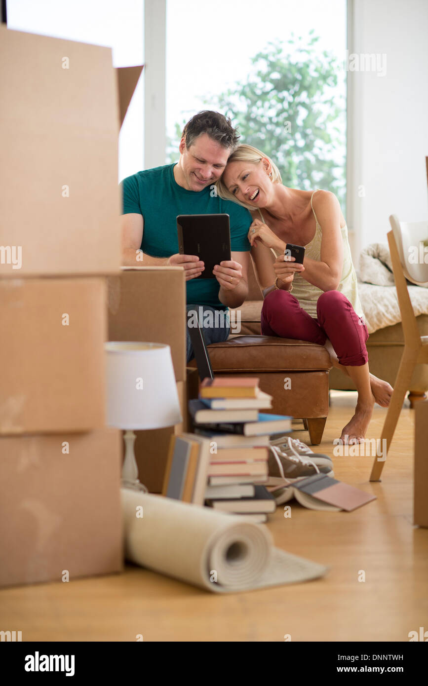 Couple using tablet pc in new home Banque D'Images
