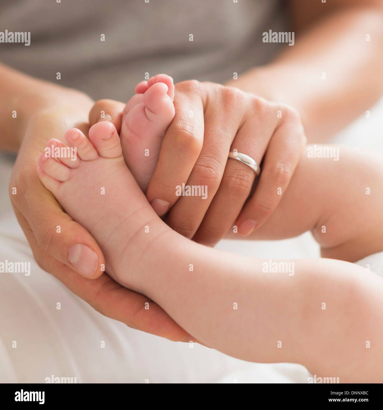 Mother holding Baby Boy's (2-5 mois) pieds Banque D'Images