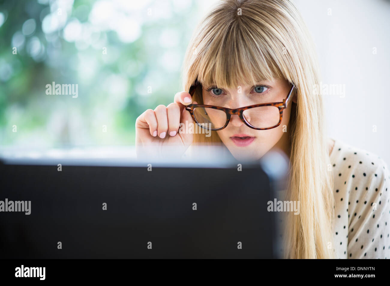 Femme portant des lunettes working on computer Banque D'Images
