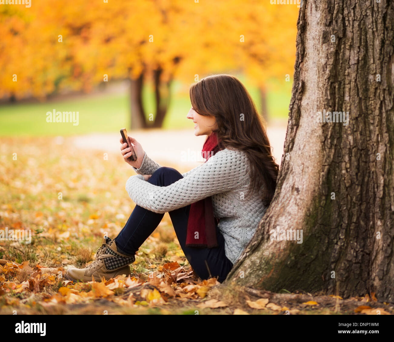 USA, l'État de New York, New York City, young woman using cell phone in Central Park Banque D'Images