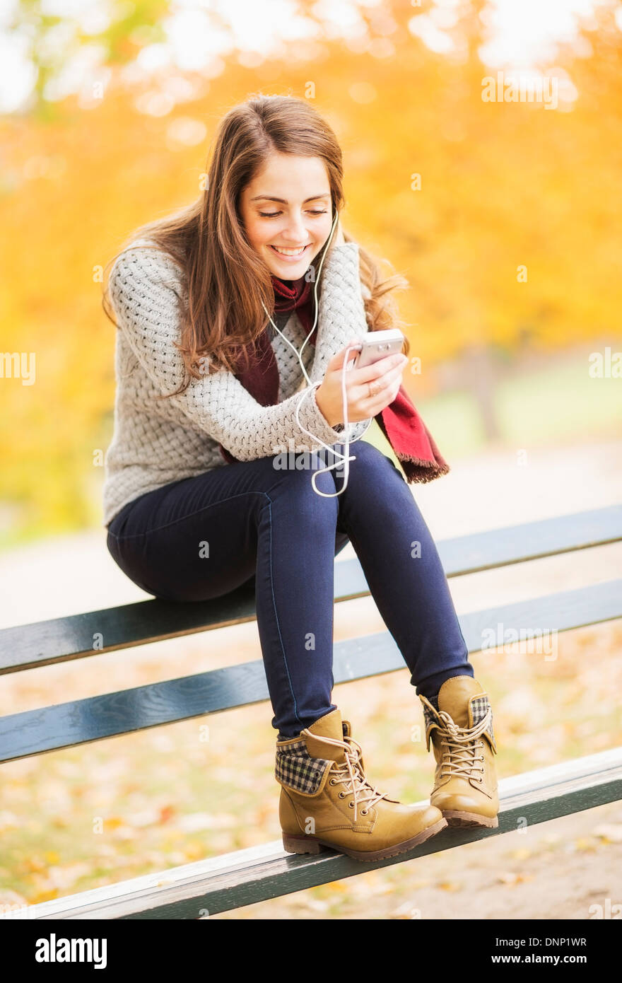 USA, l'État de New York, New York City, young woman using cell phone in Central Park Banque D'Images