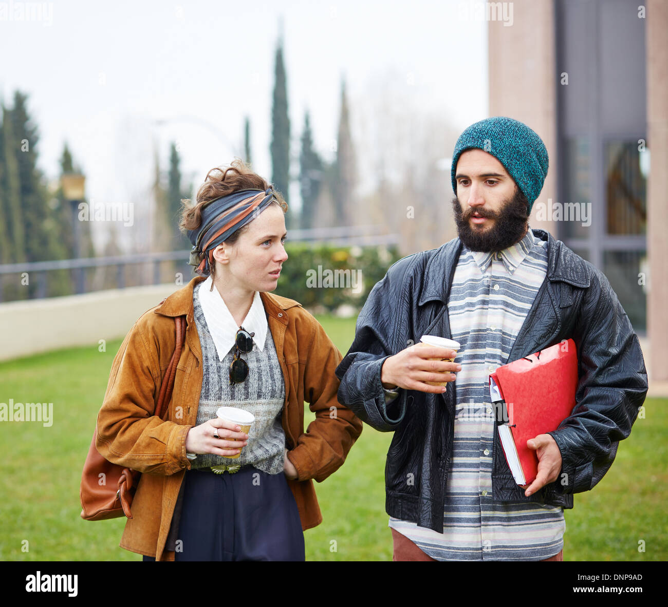 Couple Hipster de parler et de boire du café pour aller au campus universitaire Banque D'Images