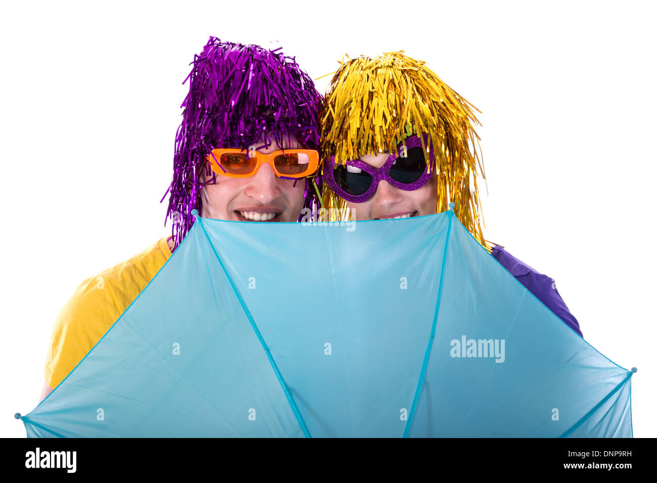 Couple à la mode avec des lunettes et perruques protégé par un parapluie Banque D'Images