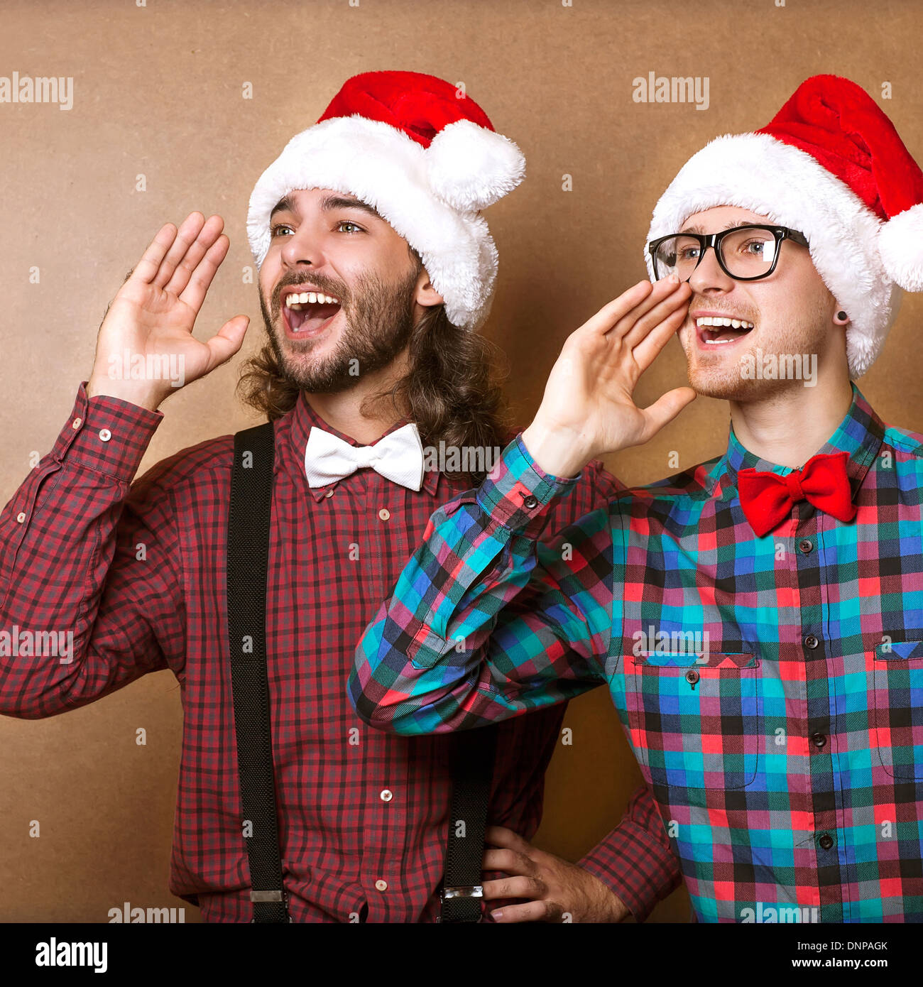 Deux mecs en vêtements hippie du Père Noël dans un cri de Noël Banque D'Images